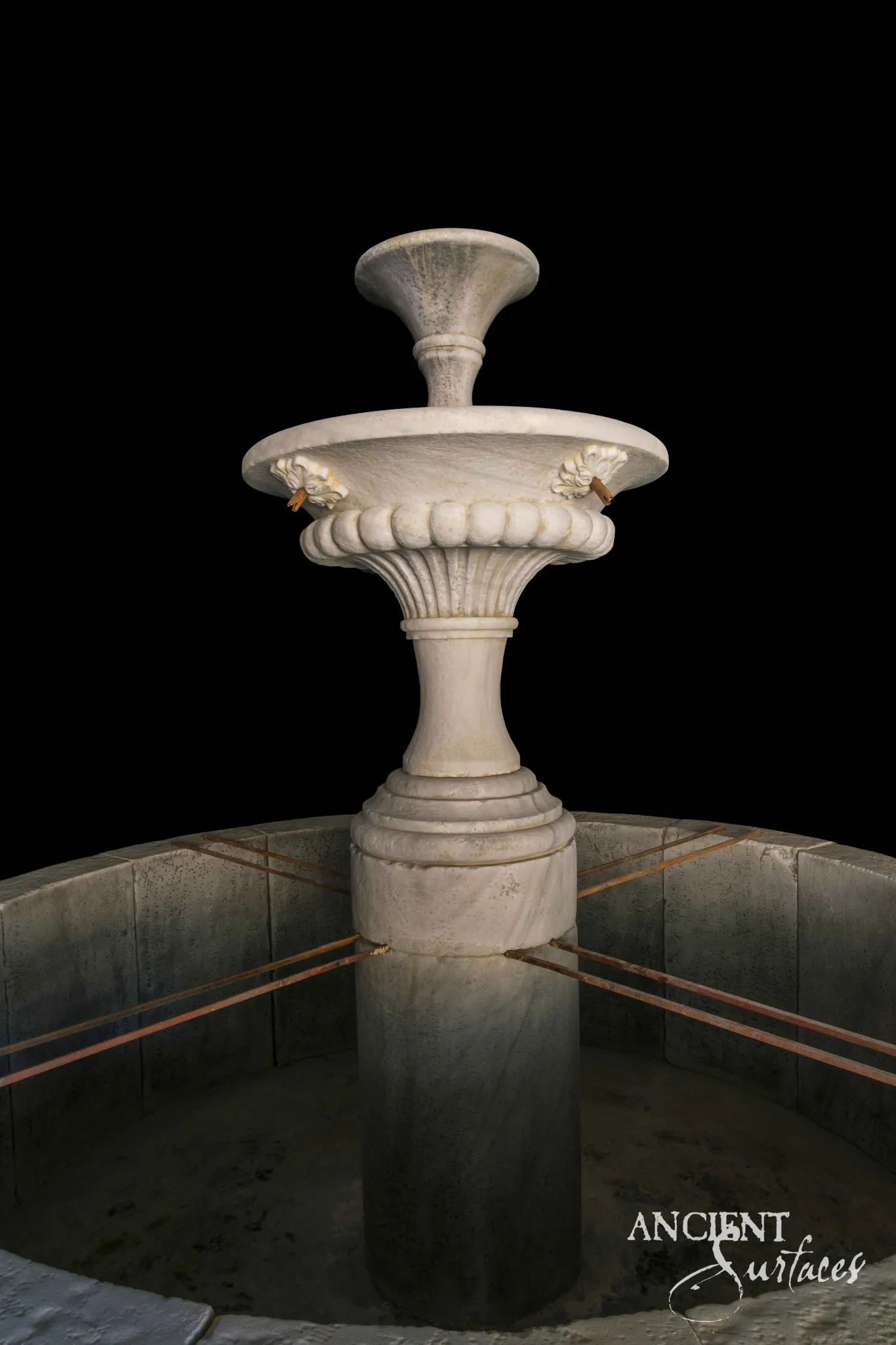 Two tier reclaimed antique white marble pool fountain from Ancient Surfaces with a gadrooned lower bowl, two carved lion head spouts and a flared upper tazza on a turned baluster stem