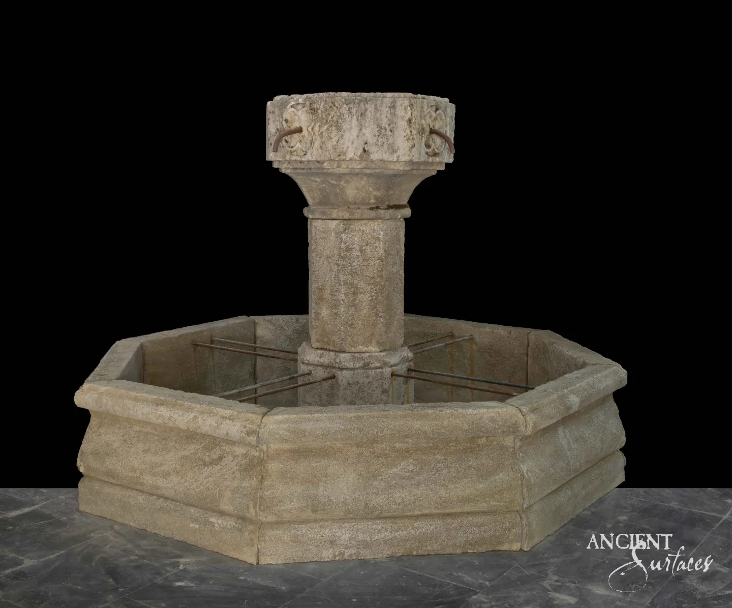 Octagonal reclaimed antique limestone pool fountain from Ancient Surfaces in warm sand toned stone, with a rounded moulded coping, a carved drum capital and two iron spouts above the basin